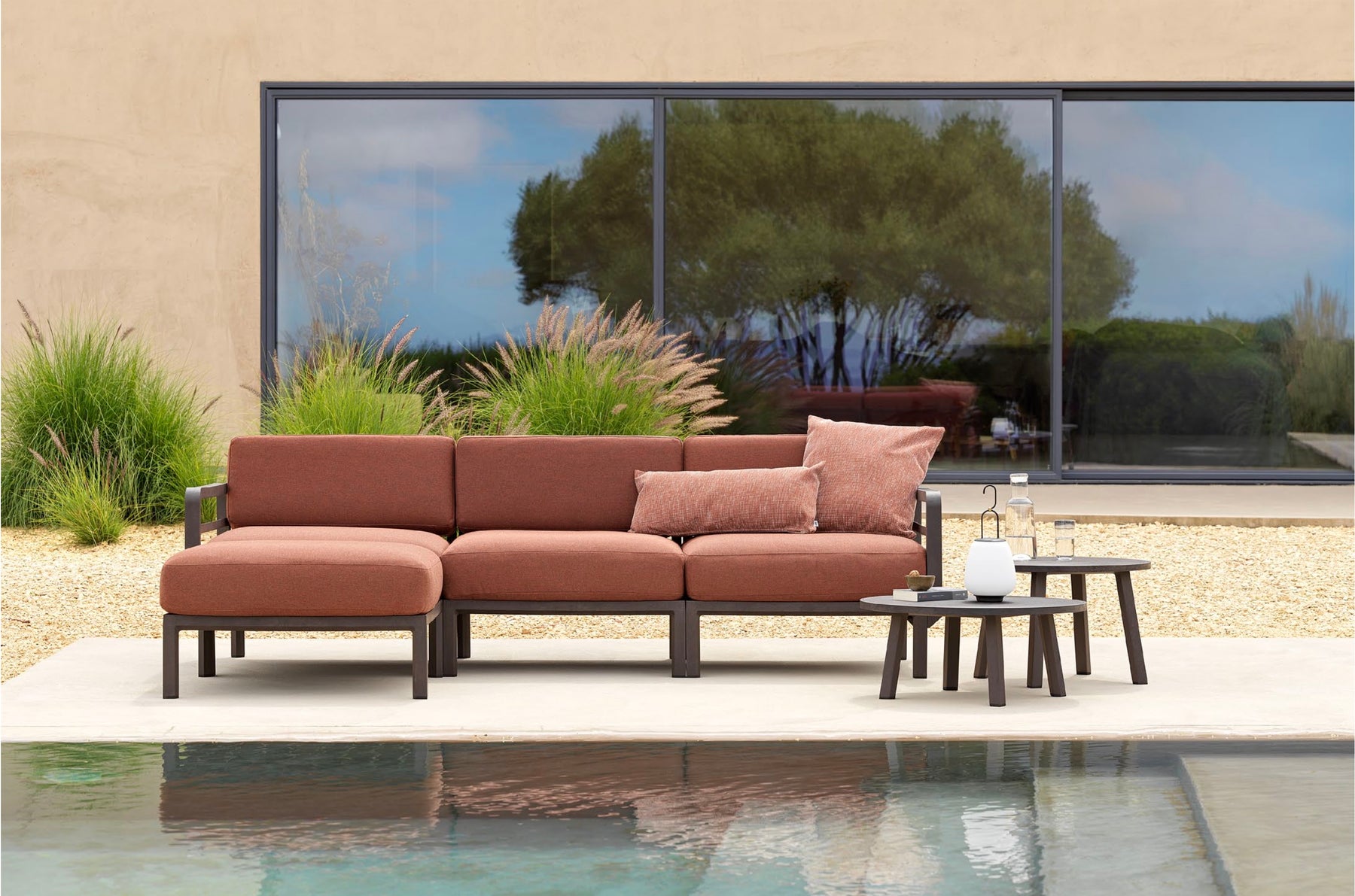 Terracotta-coloured modular Nardi seating beside a swimming pool